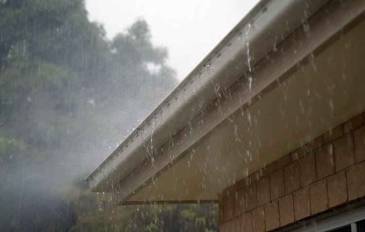 rain pouring down on roof and gutters